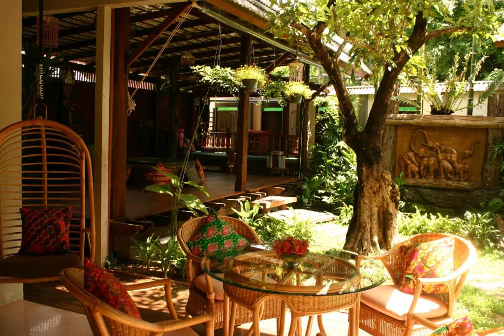 a patio with a table and chairs and a tree at Pak Chiang Mai in Chiang Mai