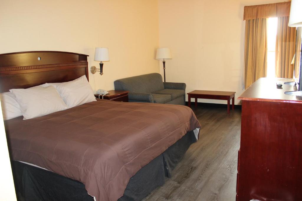 a hotel room with a bed and a chair at Truckerz Inn in Jacksonville