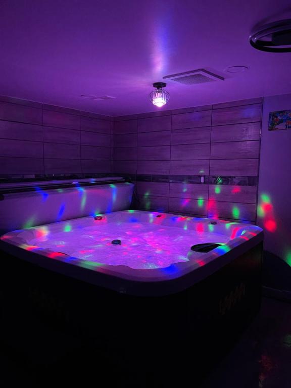 um quarto roxo com uma grande banheira com luzes em Adults Only vacation rental with Hot tub- NO PARTIES em Detroit