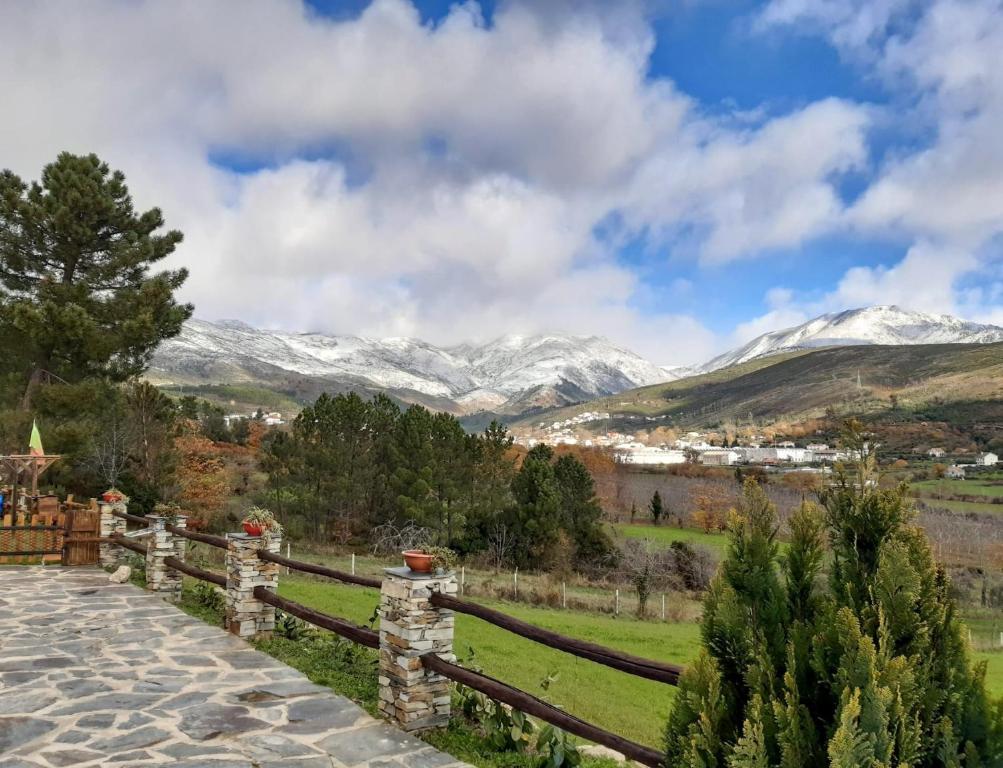 uma vista para as montanhas cobertas de neve a partir de uma cerca em Quinta das Courelinhas - Alojamento Local - Serra da Estrela em Unhais da Serra