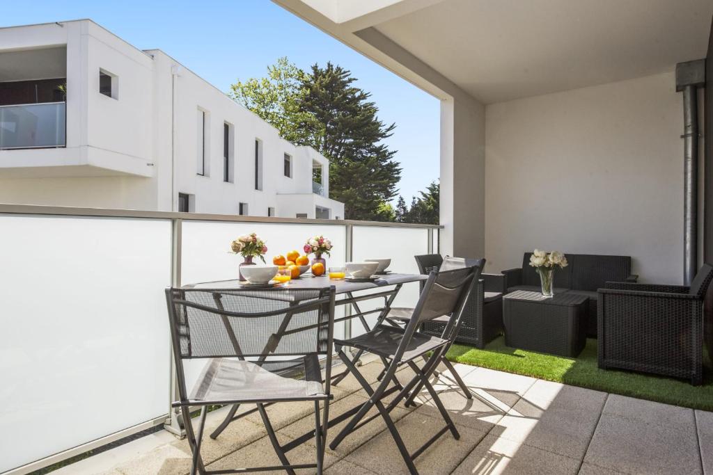 patio con mesa y sillas en el balcón en Superb apartment with a beautiful balcony - Anglet - Welkeys, en Anglet