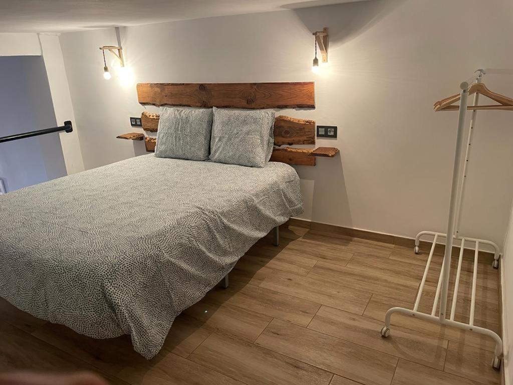 Un dormitorio con una cama con cabecero de madera. en Precioso loft en Olula del Río, en Olula del Río