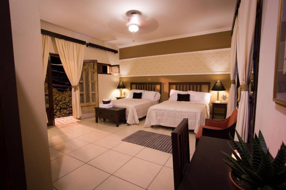 a hotel room with two beds and a balcony at Hotel Plaza Yat Balam Anexo in Copán Ruinas