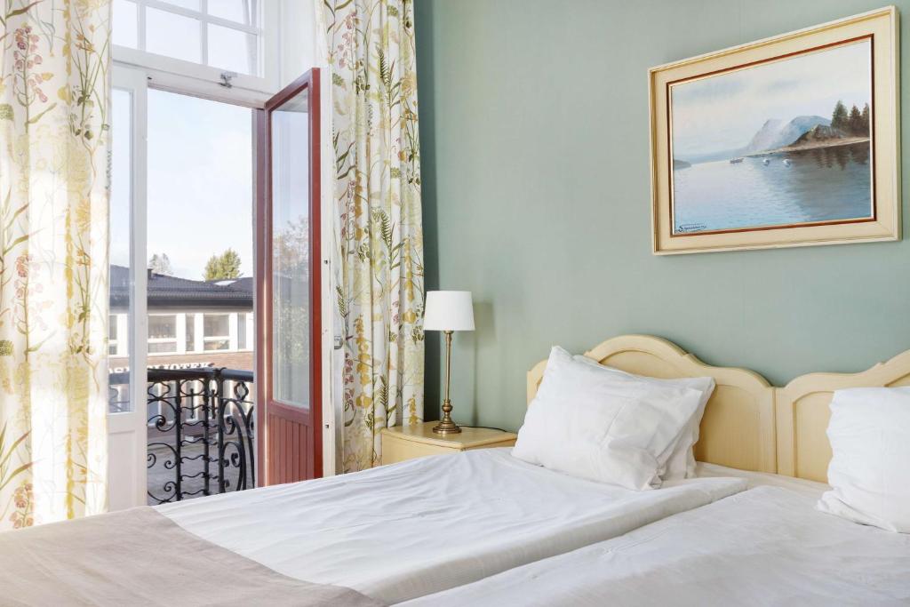 a bedroom with a bed and a window with a view at Amals Stadshotell, BW Signature Collection in Åmål