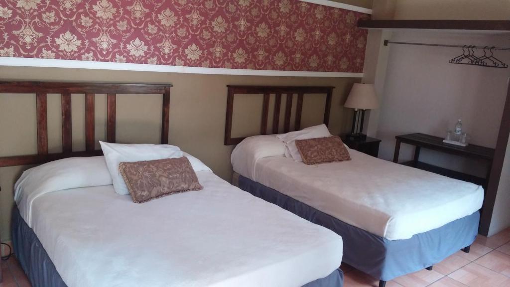 Postel nebo postele na pokoji v ubytování Hotel Plaza Yat Balam Anexo