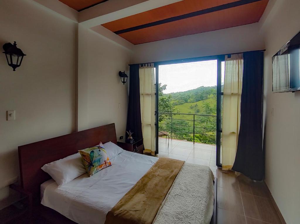 a bedroom with a bed and a large window at MANIPURA in Guaduas