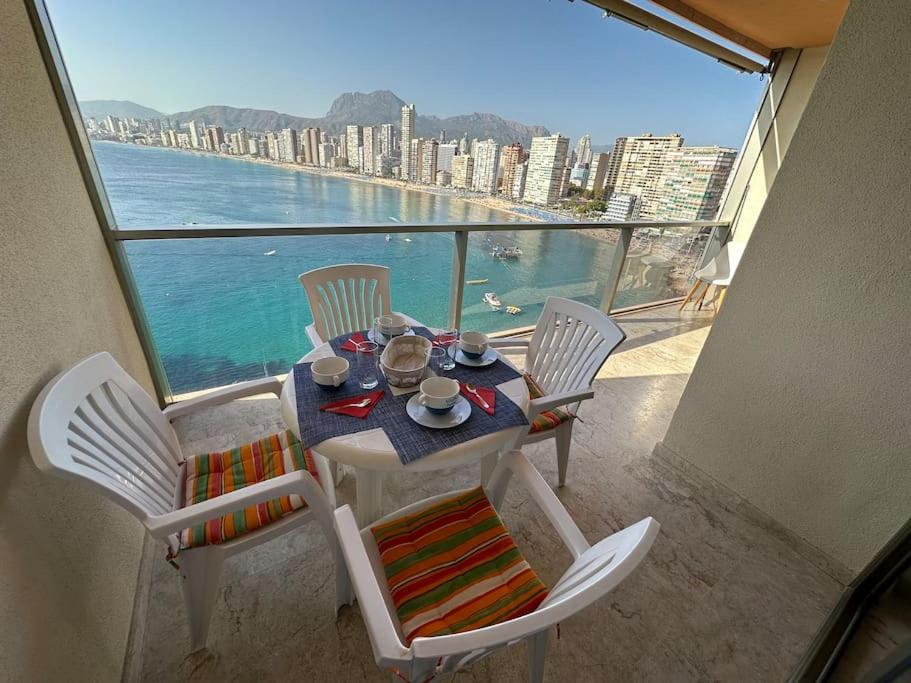 een tafel en stoelen op een balkon met uitzicht op de oceaan bij Apartamento Paraiso Lido in Benidorm
