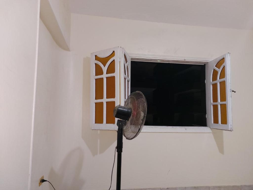 un ventilador de pie frente a una ventana en Royal Hotel en El Cairo