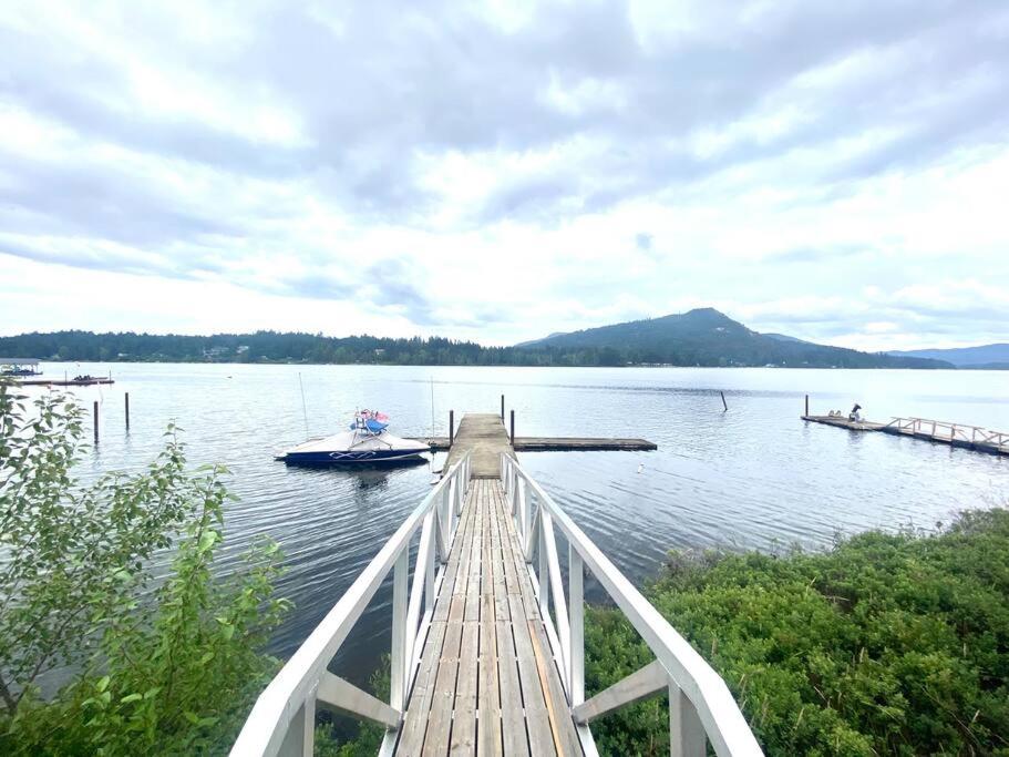 a dock with a boat on a lake at Gorgeous 3 bedroom lake house Suite! in Shawnigan Lake