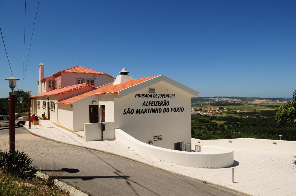 ein Gebäude mit einem Schild an der Seite in der Unterkunft HI Alfeizerão – Pousada de Juventude in Alfeizerão