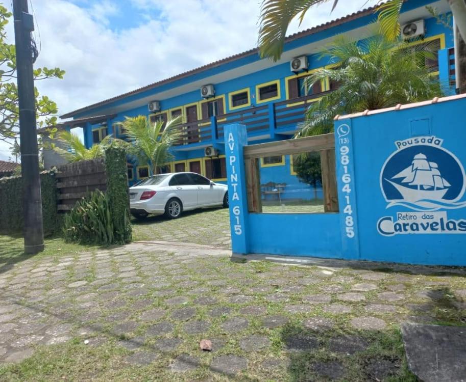 ein blaues Gebäude mit einem davor geparkt in der Unterkunft Pousada Retiro das Caravelas in Cananéia