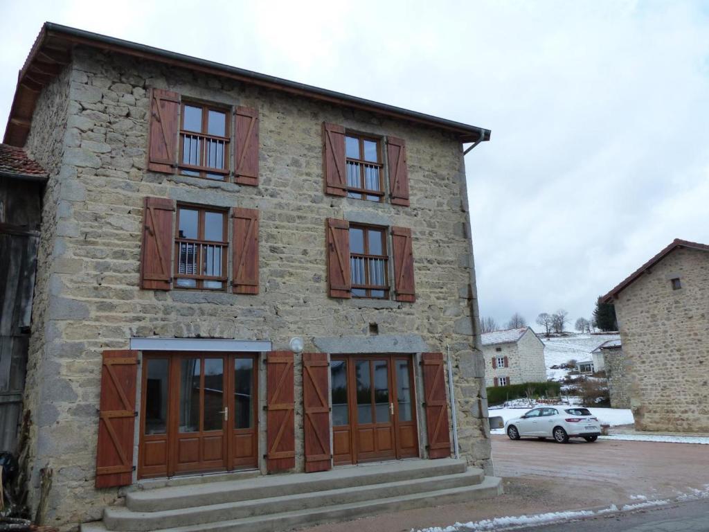 a stone building with wooden doors and windows at Gîte La Guillermie, 4 pièces, 6 personnes - FR-1-489-140 in La Guillermie