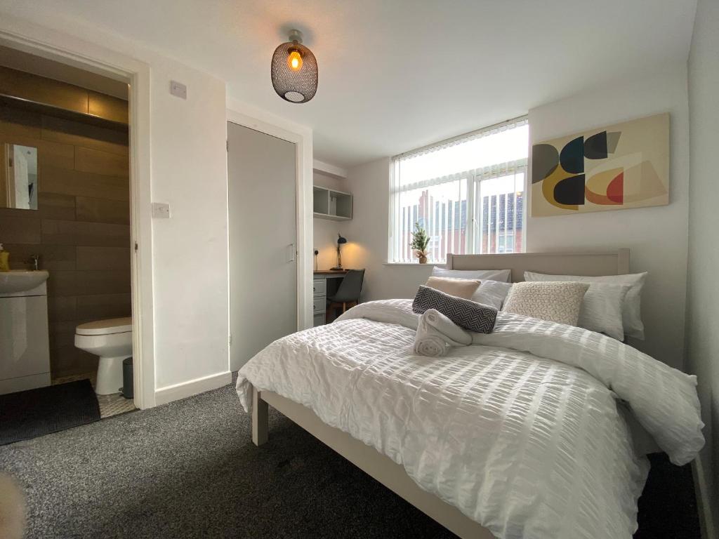 Habitación blanca con cama y baño. en Nice Living Serviced Accommodations 2 en Coventry