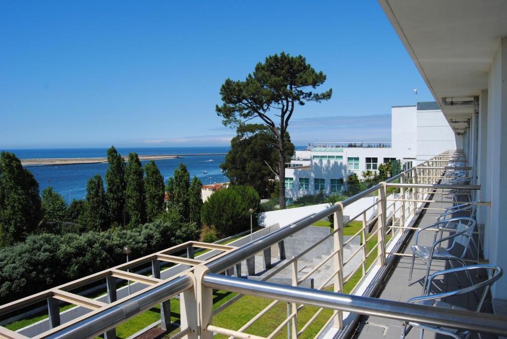 a balcony with chairs and a view of the ocean at HI Porto - Pousada de Juventude in Porto
