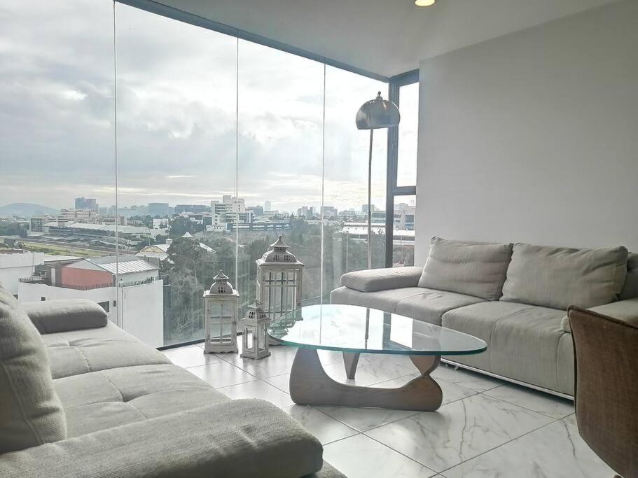 een woonkamer met een bank en een glazen tafel bij Apartamento cerca de Centro CitiBanamex in Mexico-Stad