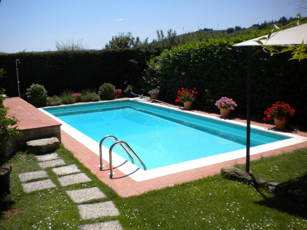 una piscina en un patio con flores en appartamento Ciocci, en San Gimignano