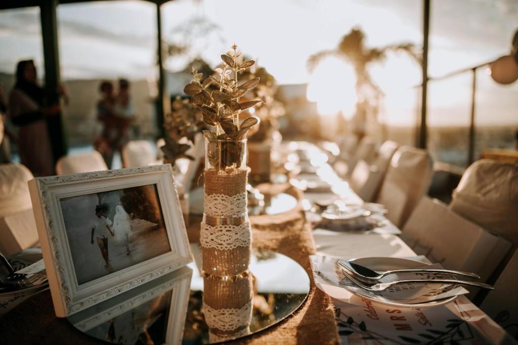 une longue table à manger avec une photo et un cadre dans l'établissement Hotel Grand Q Gorontalo, à Gorontalo