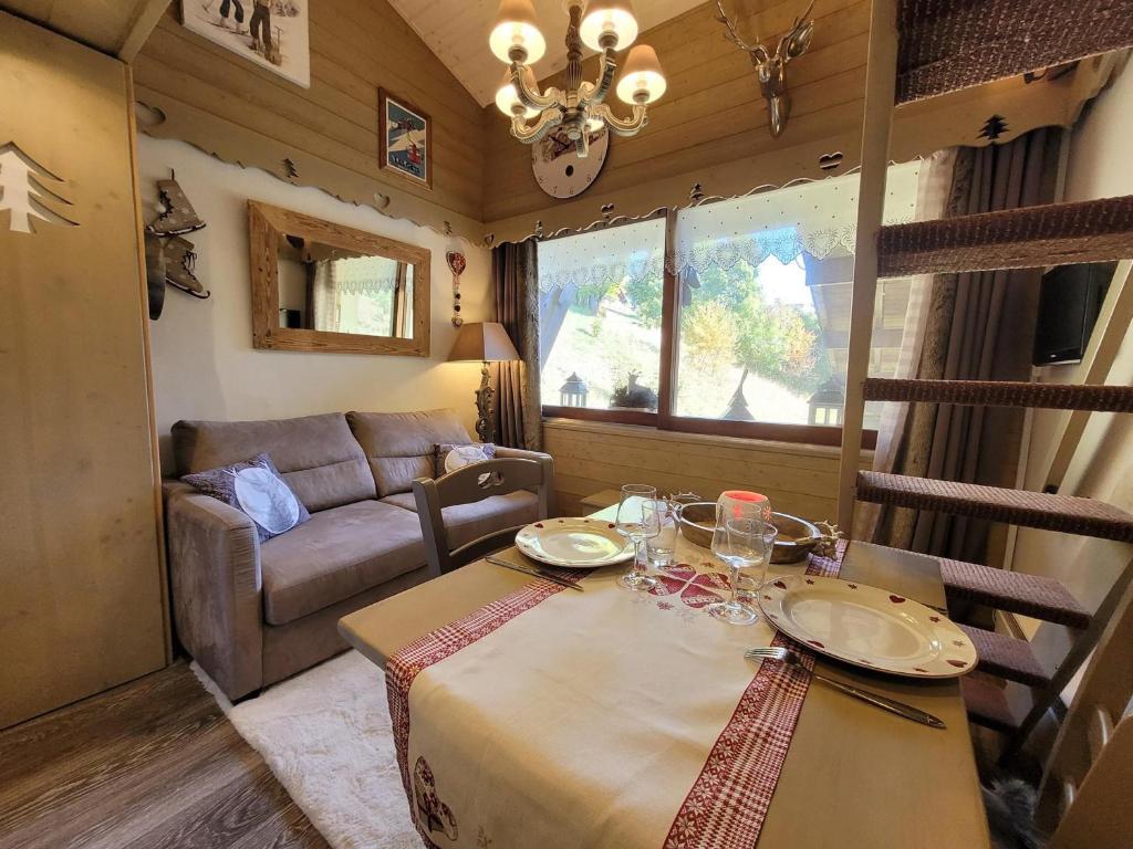 un salon avec une table et un canapé dans l'établissement Studio cocooning rénové avec parking et mezzanine - FR-1-598-113, aux Gets