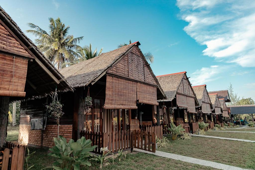 a row of wooden buildings in a row at Nipoh Beach Cottage in Kijal