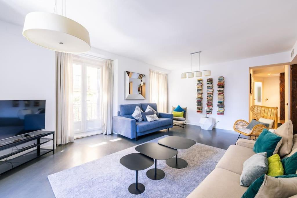 Amazing flat 5 balconies in Chueca - Gran Via في مدريد: غرفة معيشة مع أريكة وطاولة