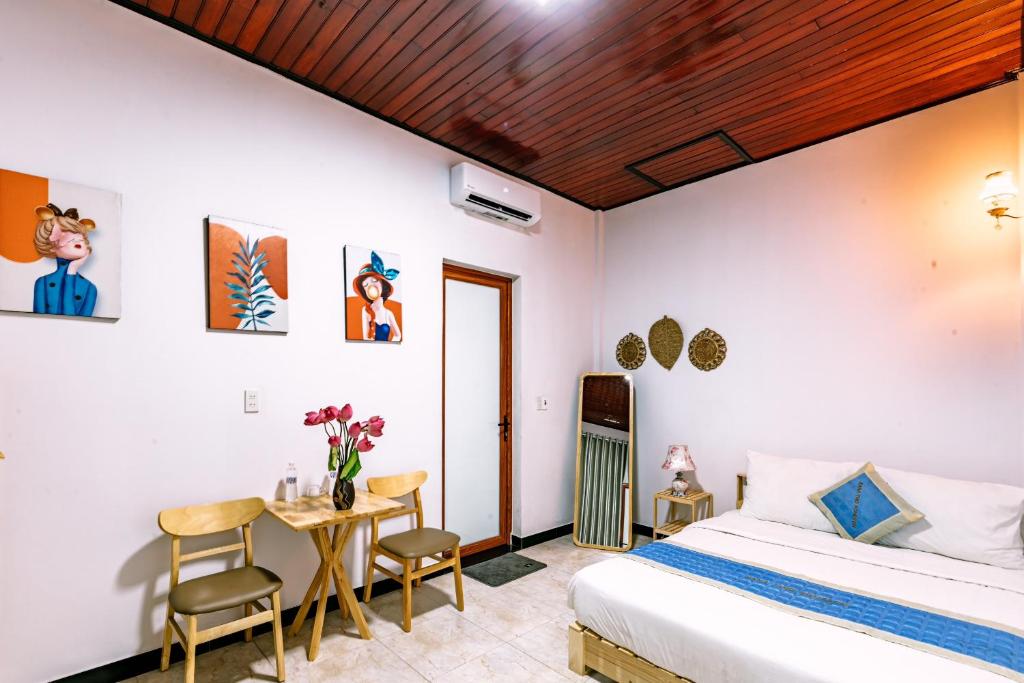 a bedroom with a bed and a table and chairs at Nana 2 Homestay in Hue