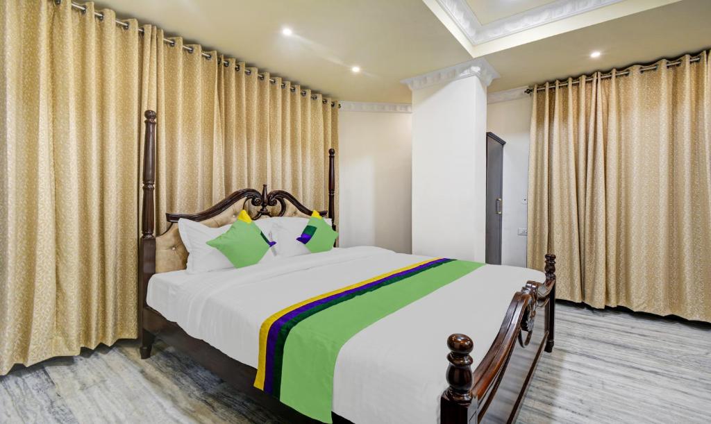 a bedroom with a large bed and curtains at Treebo Trend Jheel Mahal in Udaipur