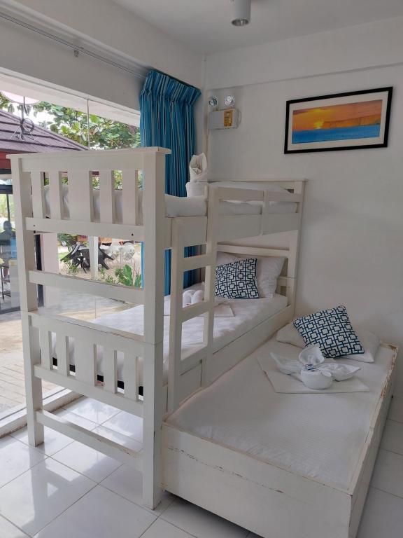 奧斯洛布的住宿－RRJ's BEACH RESORT，一间卧室设有两张双层床和一扇窗户。