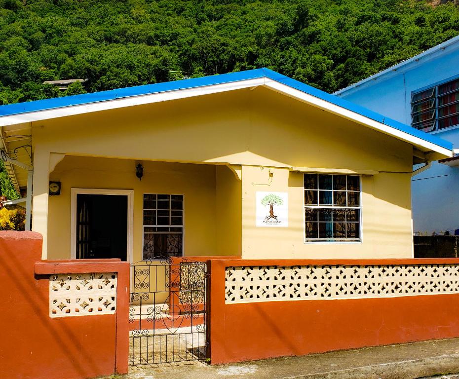 une petite maison avec une clôture orange devant elle dans l'établissement La Kaye Nou by SMO Wellness, à Soufrière