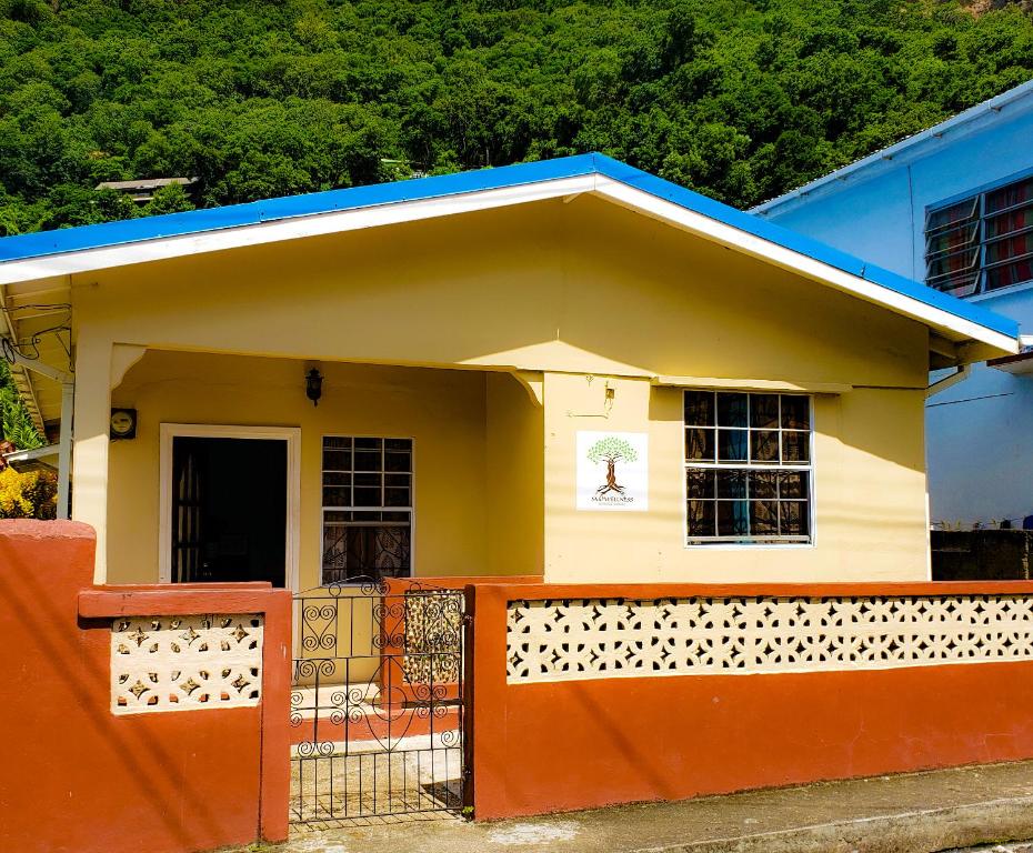 a small house with an orange fence in front of it at La Kaye Nou by SMO Wellness in Soufrière