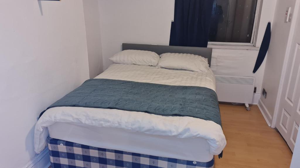 1 cama en un dormitorio con edredón azul y blanco en Stunning 1 bed flat in Newport-F3, en Newport