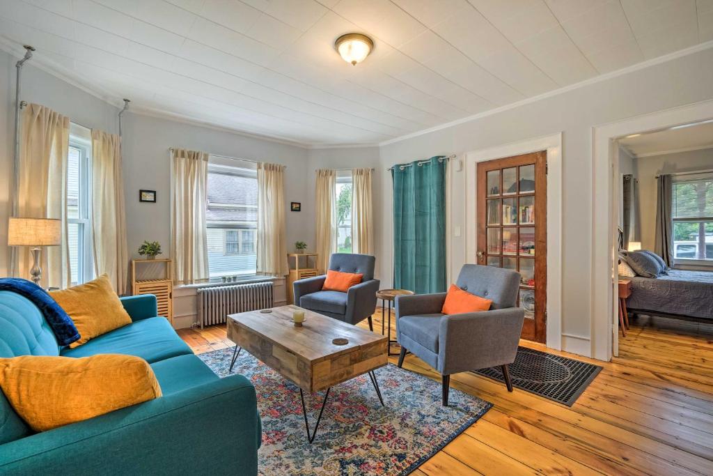 sala de estar con sofá azul y sillas en Updated Vintage Apartment Less Than half Mi to Main St, en Keene