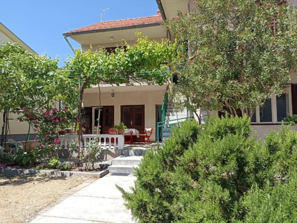a house with a garden in front of it at Apartments Slavica - free WiFi in Vodice