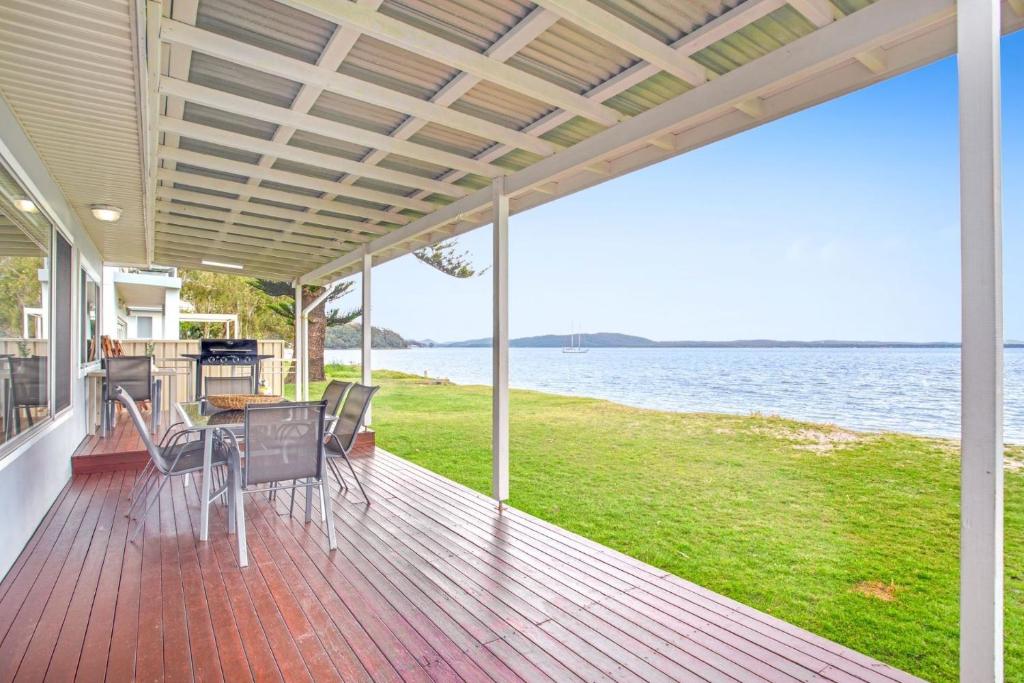 a porch of a house with a view of the water at Beached Inn Spacious beach front house in Salamander Bay