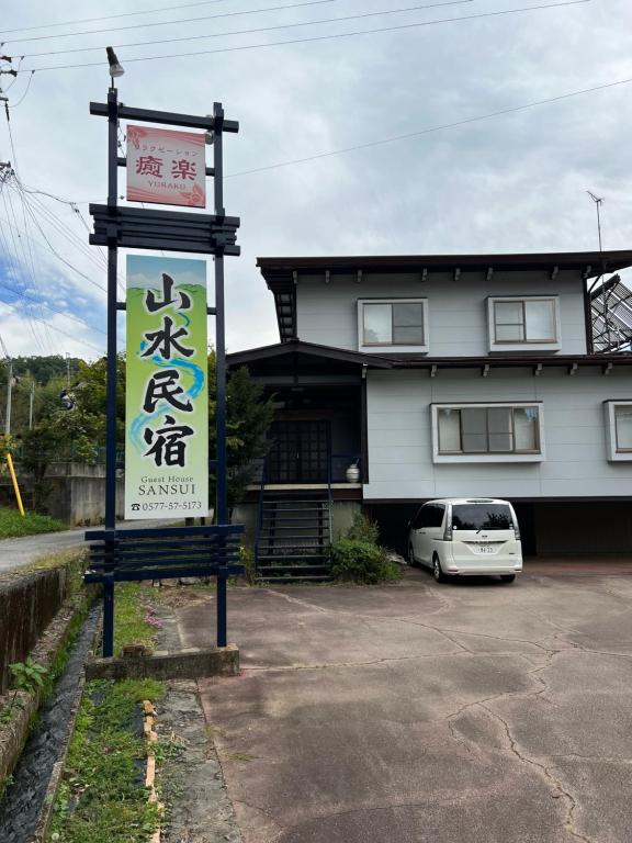 a sign in a parking lot in front of a building at 山水民宿 in Takayama