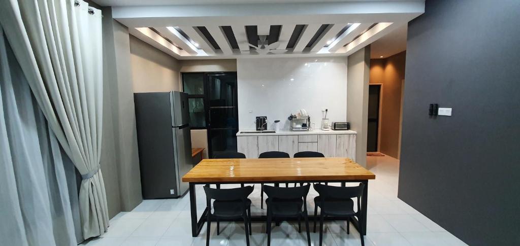 a kitchen with a table and chairs and a refrigerator at Regalia Apartment B-3-1 Kota Samarahan in Kota Samarahan