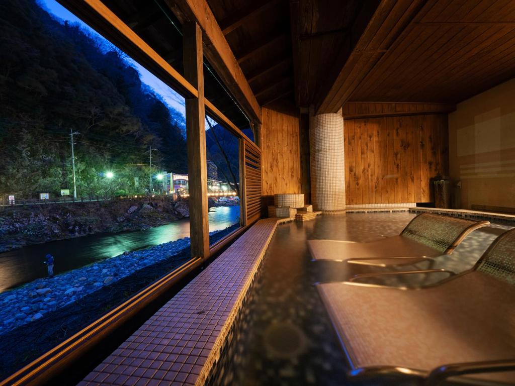 a room with a view of a river at night at Hakkei in Maniwa