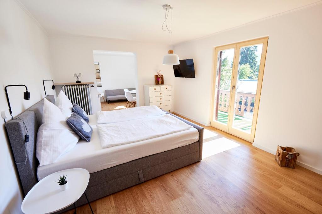 Schlafzimmer mit einem großen Bett und einem Tisch in der Unterkunft Apartmenthaus am Tegernsee - Studios mit Küchenzeile und mit Bus erreichbar in Bad Wiessee
