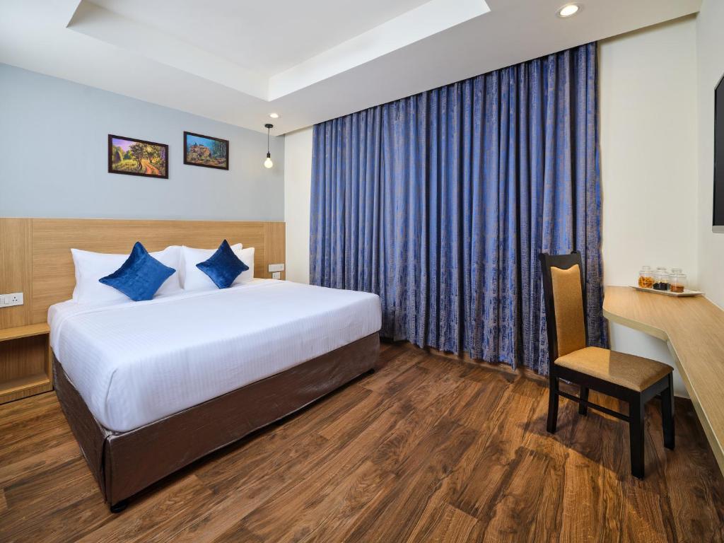 Essentia Premier Hotel Chennai OMR في تشيناي: غرفة في الفندق مع سرير ومكتب