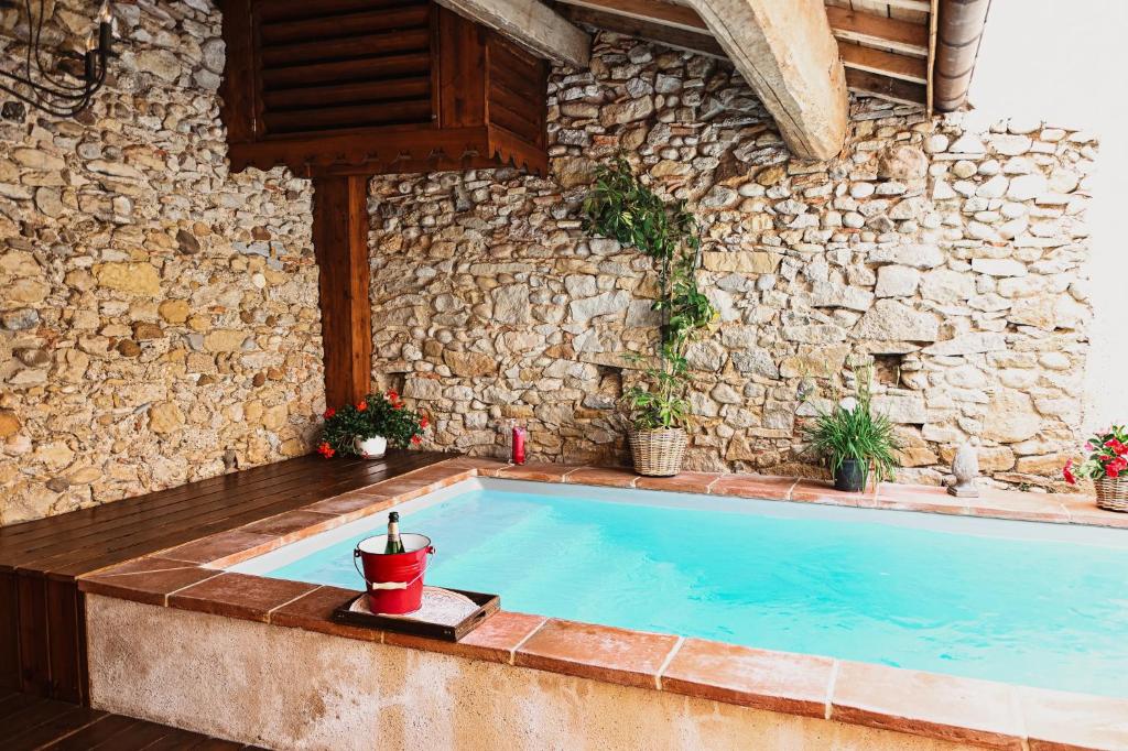 een zwembad voor een stenen gebouw bij Demeure de la Carmine, sejour bien-etre d'exception, piscine, hammam, champagne in Mirepoix