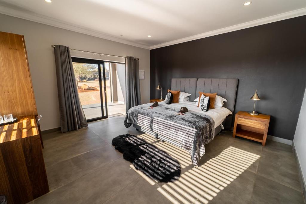 a bedroom with a bed and a large window at Leeuwkop Hunting Safaris in Kimberley