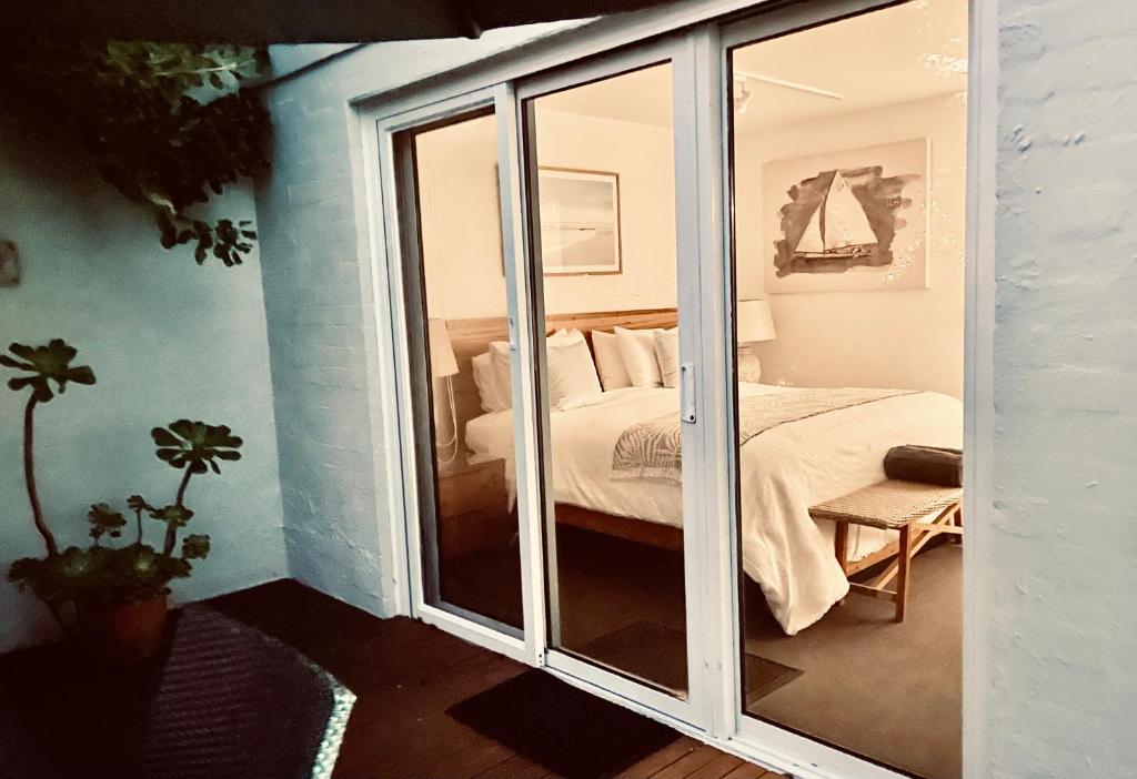 a bedroom with a bed and a sliding glass door at The Waterfront Apartment in Port Fairy