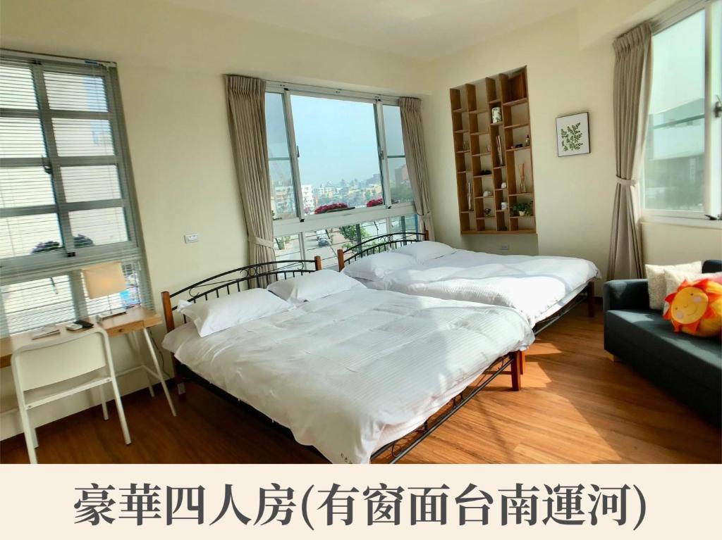two beds in a room with a window at New Color River in Tainan