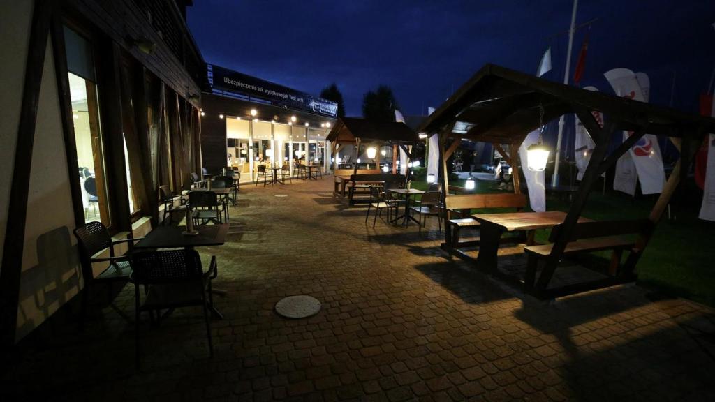 a group of tables and chairs on a street at night at Hotel Galion in Gdańsk
