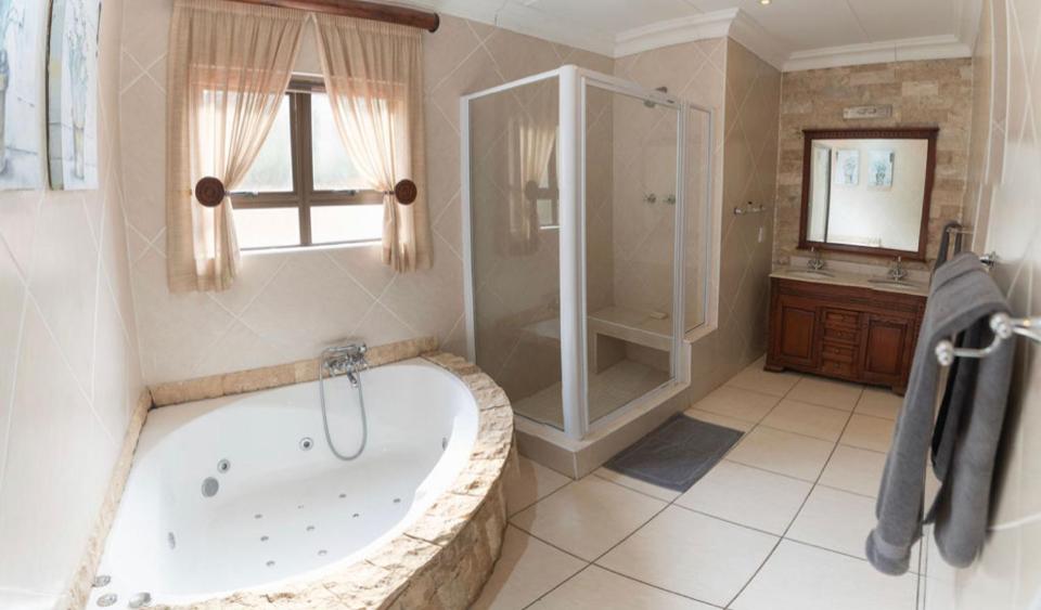 un ampio bagno con vasca e doccia di Gracelands Beach Lodge a Ramsgate