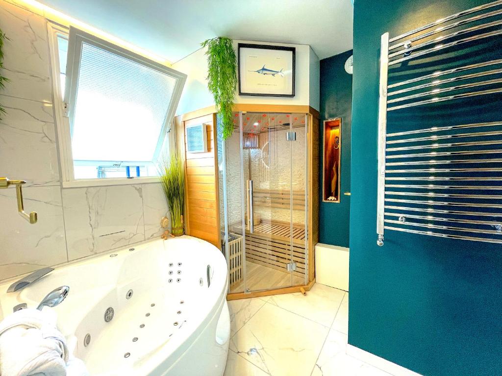 a bathroom with a tub and a shower and a toilet at Votre Escale Boule d Or Sauna & Spa in Niort