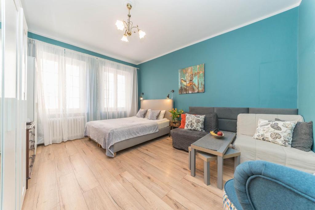 a blue living room with a couch and a table at Apartament Przytulny Starówka Old Town Piwna in Gdańsk