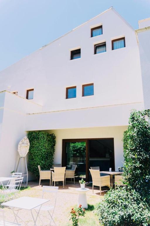 a white building with a patio with chairs and a table at Hotel Villa Sveva in Cagliari
