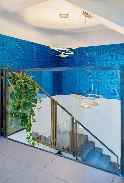 a room with blue walls and a staircase with a plant at Hotel Villa Sveva in Cagliari