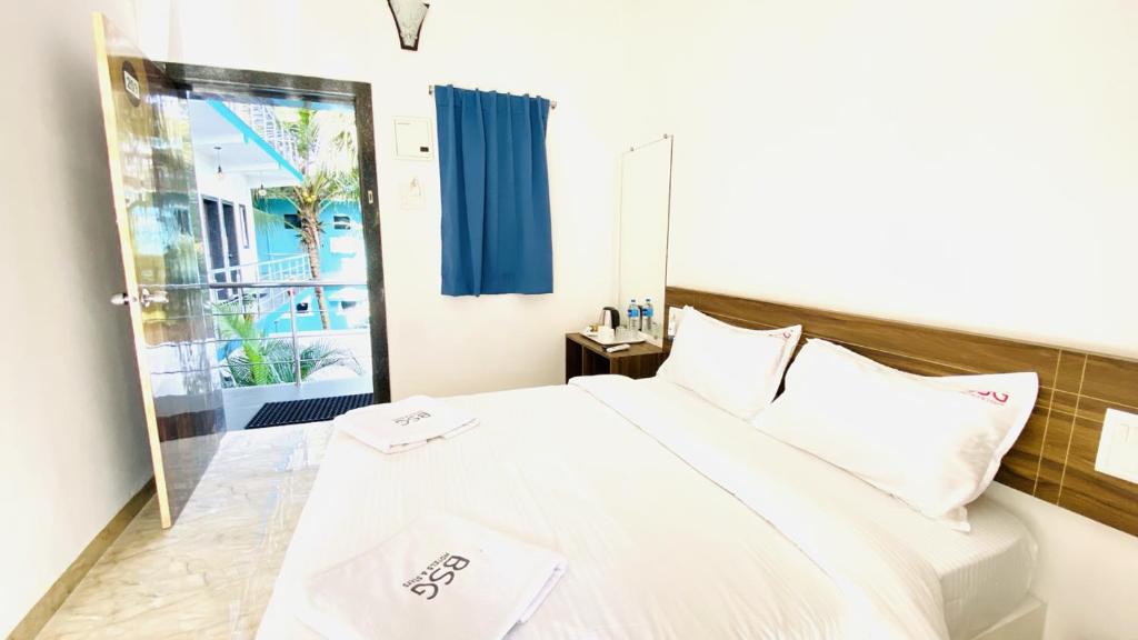 1 dormitorio con cama blanca y ventana en BSG Stay - Turtle Beach Morjim Goa, en Morjim
