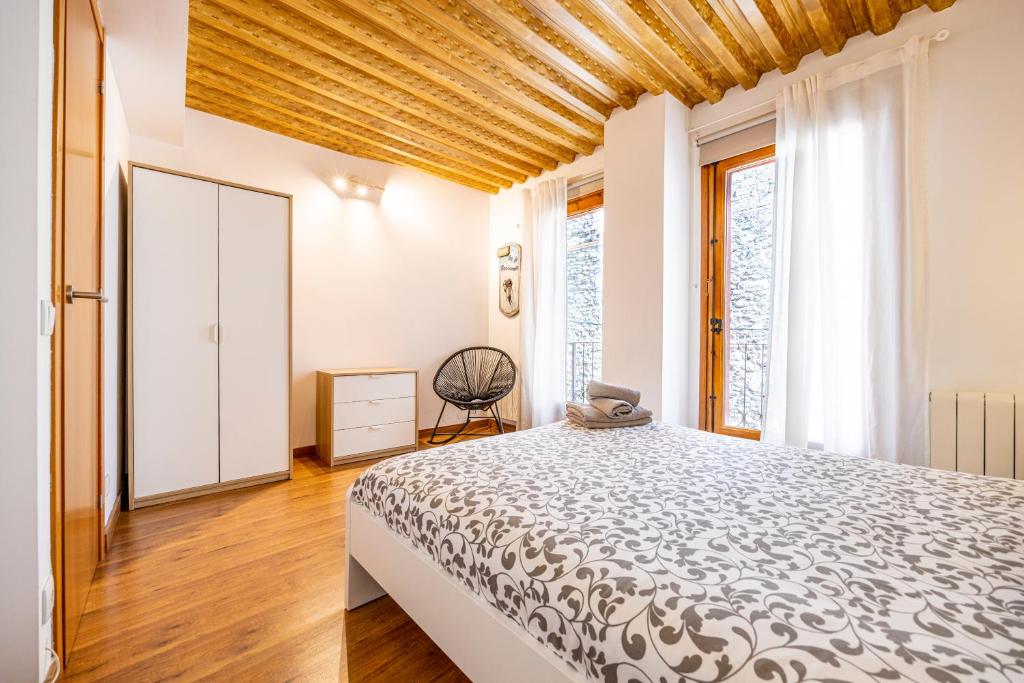 プッチェルダーにあるCal Muntanyàの木製の天井が特徴のベッドルーム1室(ベッド1台付)